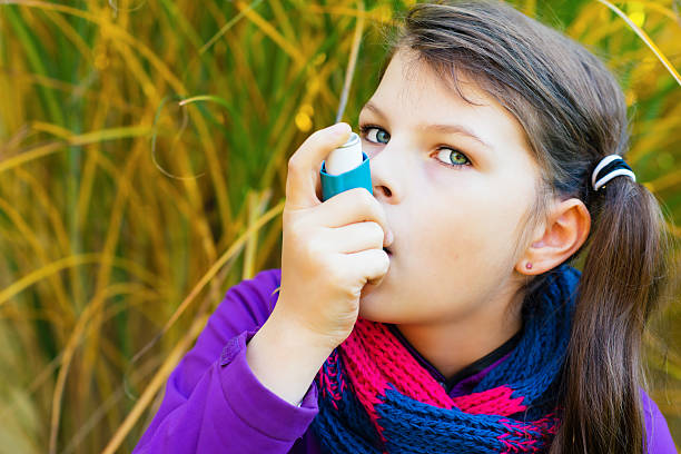 istock Girl Using Asthma Inhaler on an autumn day 496886890