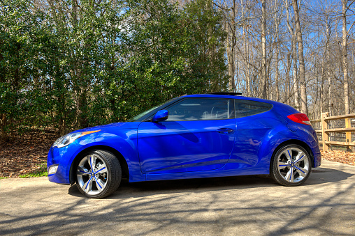 Charlotte, NC, US - February 27, 2013: First Generation Blue colored Hyundai Veloster parked near the woods.