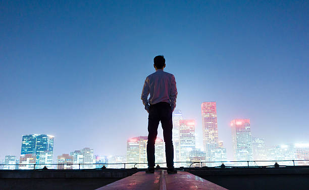 istock Businessman looking at cityscape at night 496887710