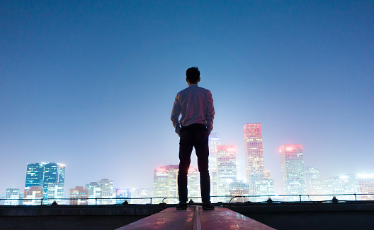 Businessman looking at cityscape at night