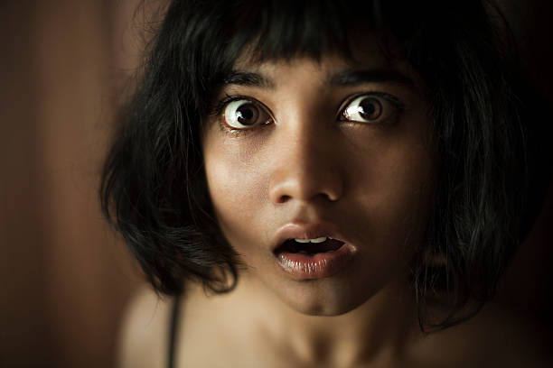 eyes and mouth widely open of surprised teenage asian girl. - spaghettibandjes stockfoto's en -beelden