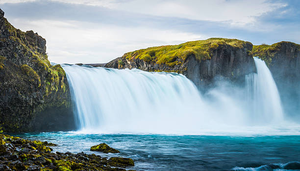 The turquoise waters of the Skjálfandafljót river cascading over the spectacular Godafoss waterfalls in the Arctic north of Iceland. ProPhoto RGB profile for maximum color fidelity and gamut.