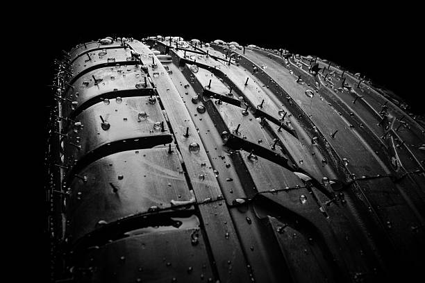 istock New wet tire on black background 496917185