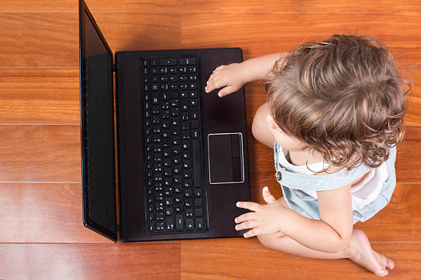 istock Top view of baby girl using a laptop computer 496919892