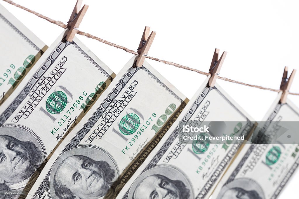 Hundred Dollar Bills Hanging From Clothesline on White Hundred Dollar Bills Hanging From Clothesline on a White Background. Abundance Stock Photo