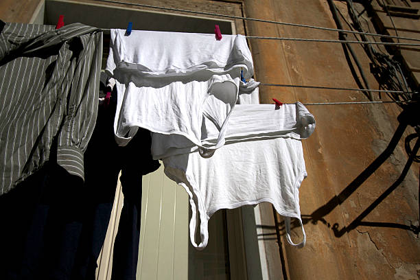 istock Men's Bleached White Undershirts on Line Outside Tenement 496922022