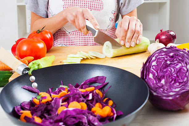 istock Woman cutting fresh cucumber 496924598