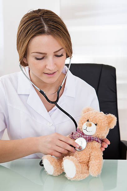 istock Female Doctor Examining Teddy Bear 496925692