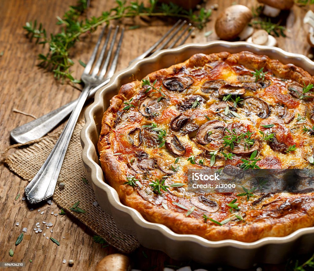 Mushroom quiche on a rustic wooden table Vegetarian dish with the addition of brown mushrooms, mozzarella, herbs, tasty and nutritious 2015 Stock Photo