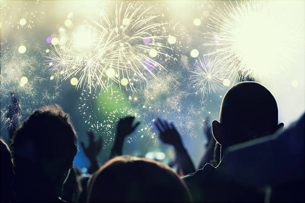 New Year concept - cheering crowd and fireworks stock photo