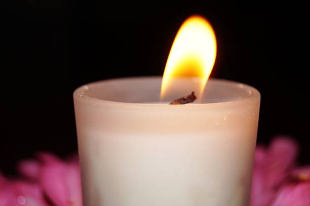 istock Burning Candle with flower petals. 496940633