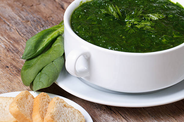 green spinach soup with croutons close up on the table. horizontal .