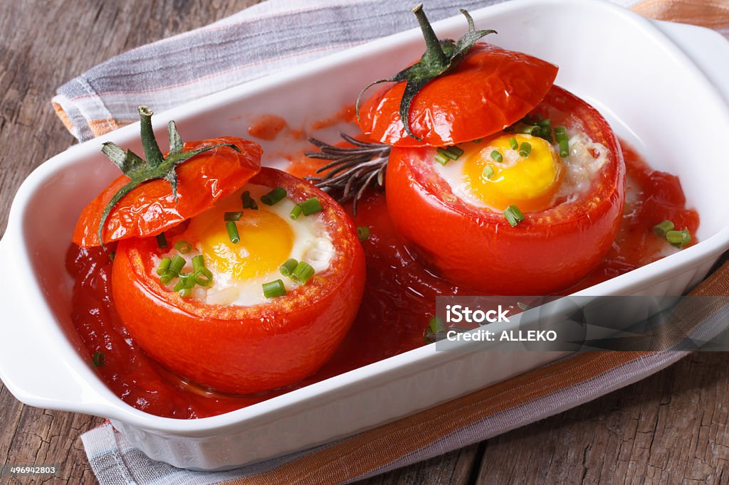 Eggs baked in tomato top view. close up Eggs baked in tomato top view. close up horizontal. Appetizer Stock Photo