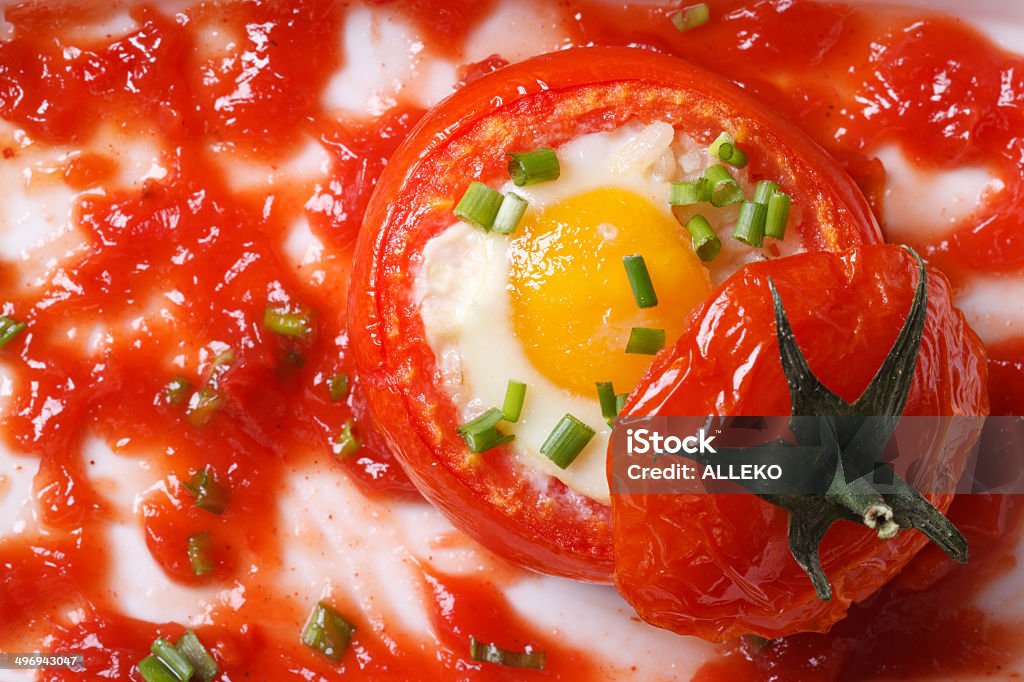 Eggs baked inside ripe tomatoes and sauce. top view Eggs baked inside ripe tomatoes and sauce. top view close up horizontal . Appetizer Stock Photo