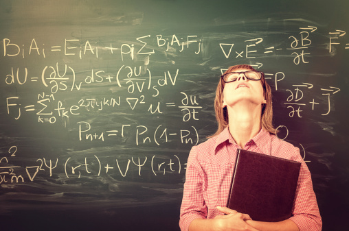 Close-up on female student or teacher in horn rimmed glasses standing against green chalkboard. She is tired of learning, teaching, school and exams. Retro style. Heavy processing for retro look, slight vignette added.