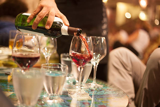 istock waiter pouring red wine into glasses 496945893