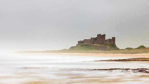 castello di bamburgh - bamburgh northumberland england beach cloud foto e immagini stock