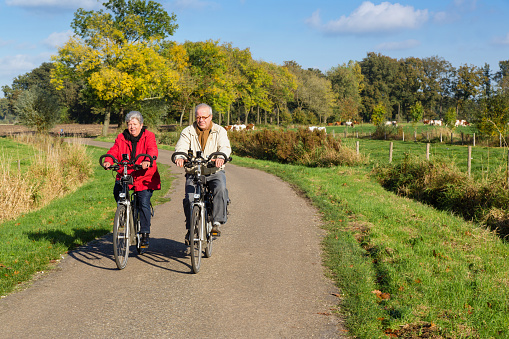 Senior man and woman on bicycles on a dutch countryroad