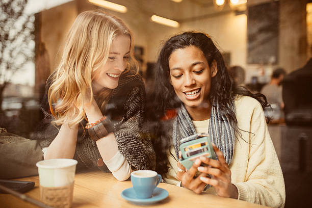 Check out this new app I downloaded Girlfriends using Smartphone in Coffeeshop dumbo new york photos stock pictures, royalty-free photos & images