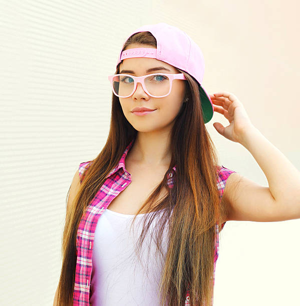 pretty girl wearing pink tonos de una gorra de béisbol y gafas - women sunglasses little girls glamour fotografías e imágenes de stock