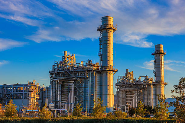 Natural gas fired turbine power plant,fall,field,CA Natural gas fired turbine power plant with it's cooling towers rising into a cloud filled blue sky power station stock pictures, royalty-free photos & images