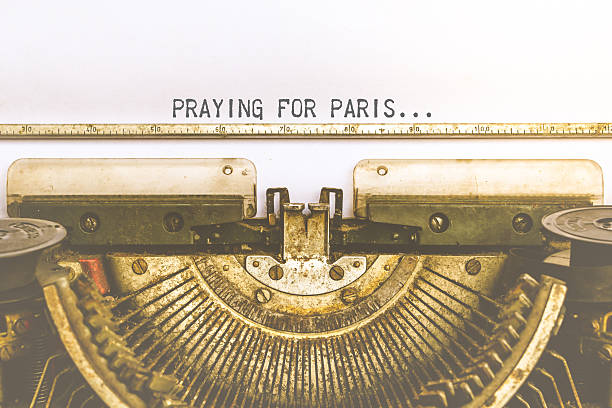 istock Typewriter and white paper with a word Praying For Paris, 496955778
