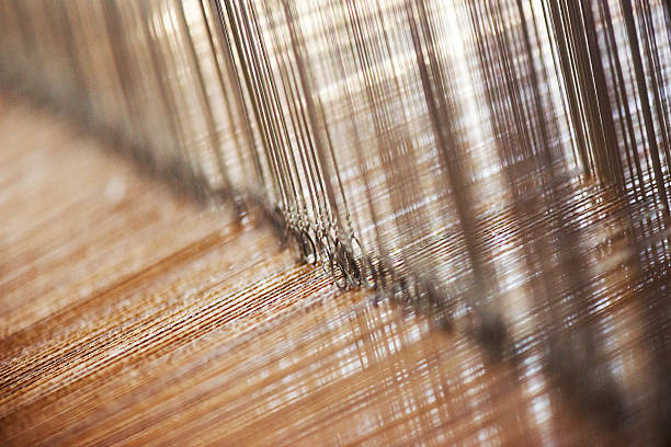 Weaving Close-up of the cotton yarn which is being woven by a loom loom photos stock pictures, royalty-free photos & images