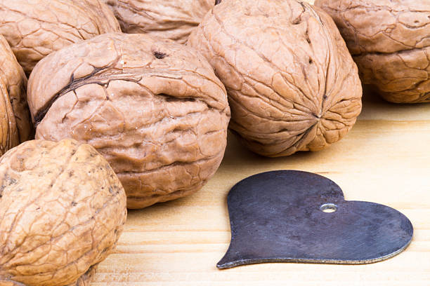 whole walnuts on rustic wooden table with a heart stock photo