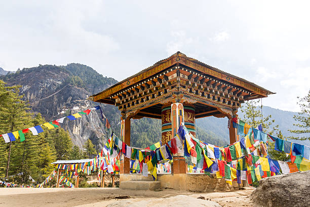 Prayer wheel A giant prayer wheel at the ascent to the tiger's nest,Bhutan. The tigers nest is the most famous temple of Bhutan, it is  visible in the background. taktsang monastery photos stock pictures, royalty-free photos & images