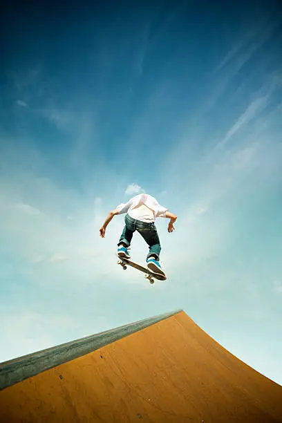 skater in jump over skating poligon ramp