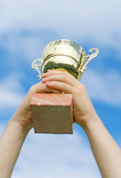 istock Hand of winner with a gold cup. 496973745