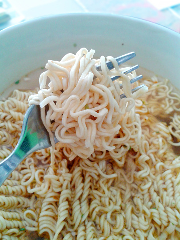 Instant noodle rolls on fork in a bowl
