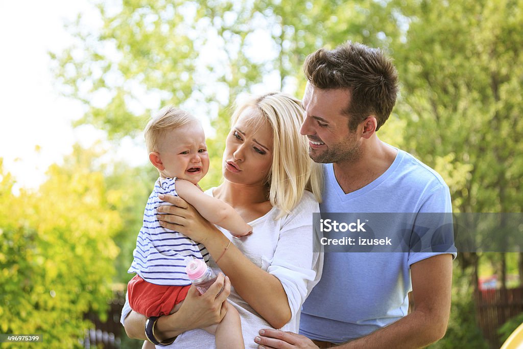 Couple with baby Outdoor portrait of parents with their toddler. Mother consoling crying baby. 6-11 Months Stock Photo