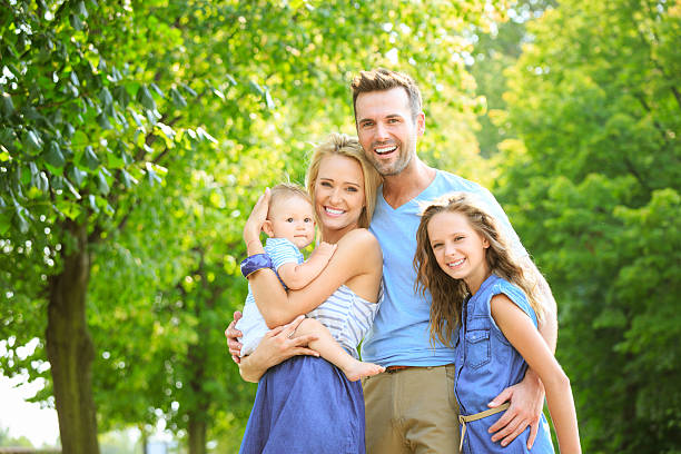 Outdoor portrait of happy parents with their children. 