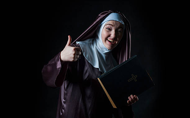 Nun advertises bible Young nun advertises bible and shows thumbs nun catholicism sister praying stock pictures, royalty-free photos & images