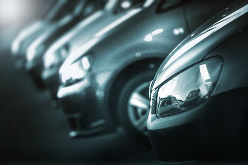 Hamburg, Germany -  october  4, 2014:  Close up with shallow depth of field of VW vehicles in a row at public dealership at twillight. VW is a brand of the Volkswagen Group, which is a German automobile manufacturing group based in Wolfsburg, Germany and founded in 1937.