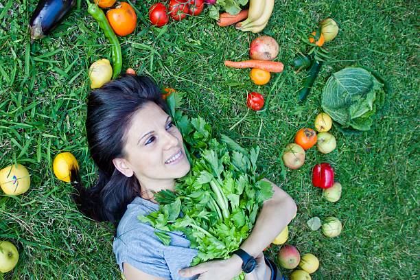 istock woman with a celery on the grass 496982638