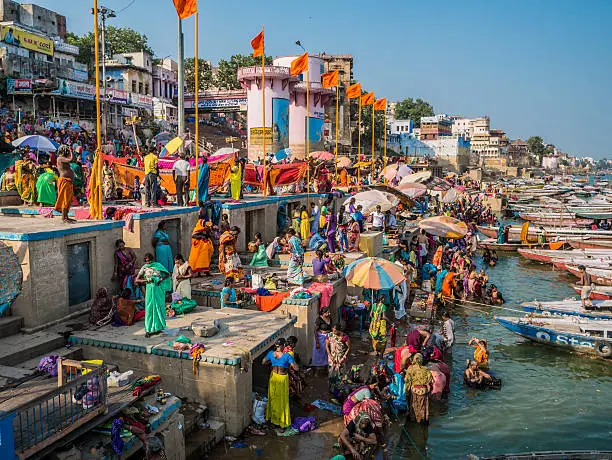 Varanasi, India - October 05, 2015: Pilgrims in Dashashwamedh Gha at the Ganges river in Varanasi . This is one of the oldest inhabited cities in the world and also the holiest of the seven sacred cities in Hinduism and Jainism and so the most important pilgrimage place for hindus. Many ghats, embankments made in steps, are placed in one of the river sides and it is where pilgrims perform ritual ablutions.
