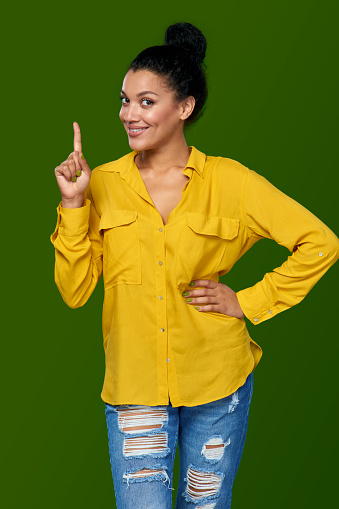 Idea. Happy mixed race african american - caucasian woman pointing her finger up