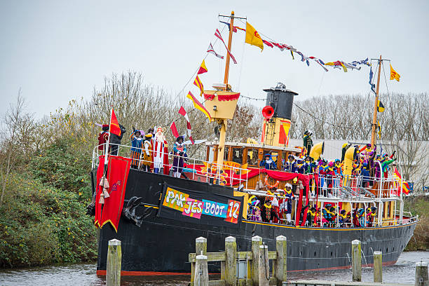 Sinterklaas arriving in The Netherlands Meppel, The Netherlands - November 14, 2015: The arrival of Sinterklaas in the city of Meppel on the steam boat Pakjesboot 12 coming from Spain. Sinterklaas is standing on the boat's bow surrounded by his helpers the  Black Petes. The arrival in Meppel is the official arrival of Sinterklaas in The Netherlands for 2015 and is broadcasted on national television. Sinterklaas is a traditional Dutch holiday for children that is celebrated on the 5th of December. zwarte piet stock pictures, royalty-free photos & images