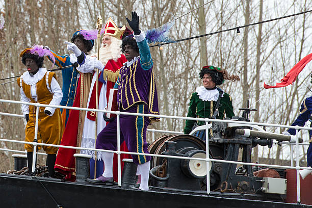 Sinterklaas arriving in The Netherlands Meppel, The Netherlands - November 14, 2015: The arrival of Sinterklaas in the city of Meppel on the steam boat Pakjesboot 12 coming from Spain. Sinterklaas is standing on the boat's bow surrounded by his helpers the  Black Petes. The arrival in Meppel is the official arrival of Sinterklaas in The Netherlands for 2015 and is broadcasted on national television. Sinterklaas is a traditional Dutch holiday for children that is celebrated on the 5th of December. zwarte piet stock pictures, royalty-free photos & images