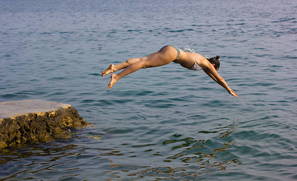 istock Female jumping into the water 496989571