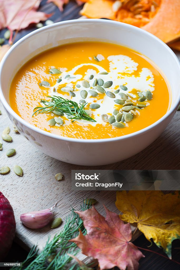 Pumpkin soup on a wooden table Pumpkin soup among autumn leaves on a wooden table 2015 Stock Photo