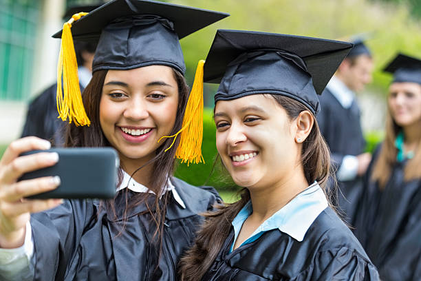 istock Happy Hispanic students taking selfie at high school graduation ceremony 496993109