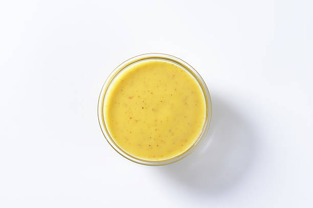spicy yellow sauce bowl of spicy yellow sauce isolated on white background hollandaise sauce stock pictures, royalty-free photos & images