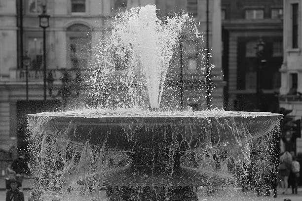 Water fountain at Trafalgar Square Water fountain at Trafalgar Square in Londen. Black-and-white picture. arma-globalphotos stock pictures, royalty-free photos & images