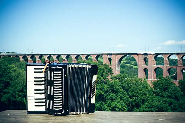An accordion in front of the largest brick bridge in the world
