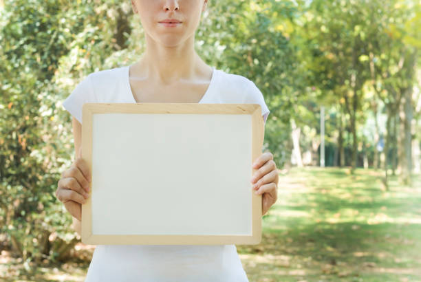 istock woman holding a whiteboard 496999572