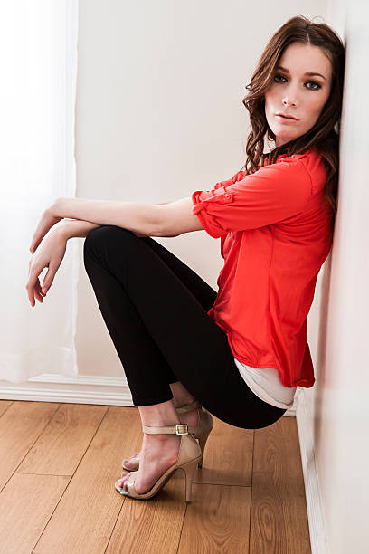 istock Sensual young woman sitting against wall 496999614