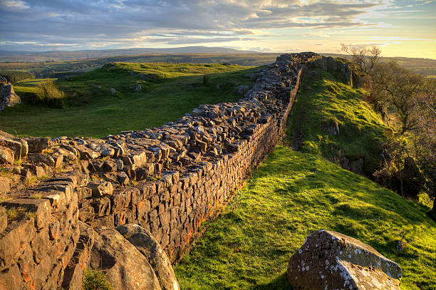 Evening Light on Hadrian's Wall A stretch of Hadrian's Wall at Walton's Crags in Northumberland, England, coloured by the setting sun northeastern england stock pictures, royalty-free photos & images